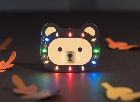 colourfully lit LED bear badge, autumn themed dark background