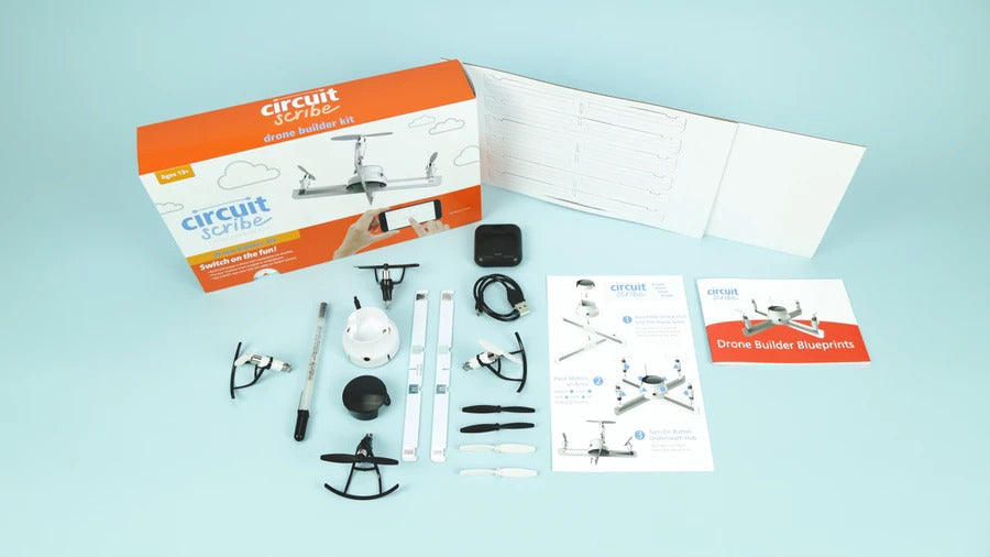 Cardboard DIY constructible drone on a light blue background. With silver conductive pen and motors and electronics